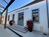 a white building with a sign that says la cave de la cite