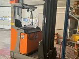 a forklift in a warehouse with a lot of pallets