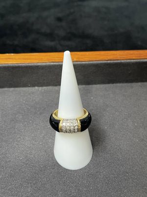 une bague noire et dorée avec un diamant serti au centre