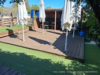 a wooden deck with umbrellas and chairs in the yard