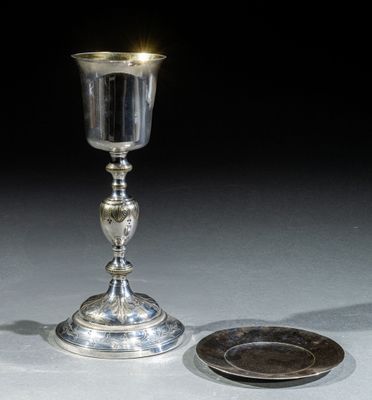 une coupe en argent et une assiette en argent posées sur une table