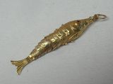 un objet en forme de poisson rouge posé sur une surface blanche