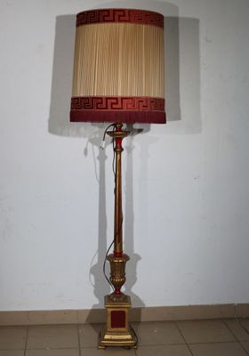 a lamp that is sitting on the floor next to a wall