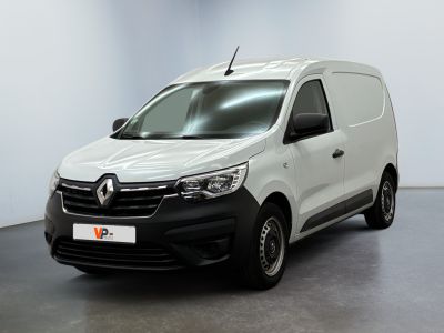 La camionnette blanche est garée dans une pièce au sol noir.