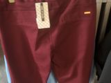 un pantalon de couleur bordeaux suspendu à un portant dans un magasin de vêtements