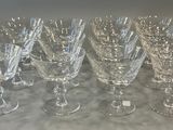 seven crystal wine glasses are lined up on a table