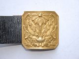 a gold belt buckle with a picture of a bird on it