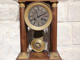 une horloge posée sur une table devant un mur de briques