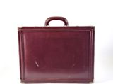 a brown briefcase sitting on a white surface