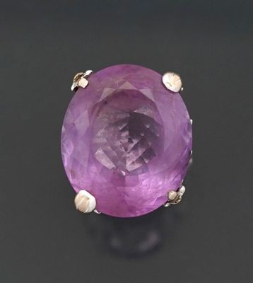 an image of a purple stone ring on a black surface
