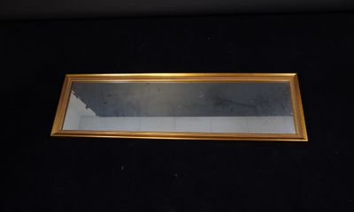 a picture of a gold framed mirror on a black surface