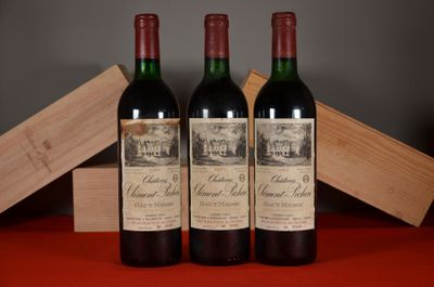 three bottles of red wine sitting on a table next to a wooden box