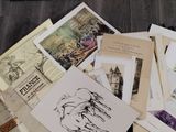 a pile of old books on the floor next to a laptop