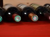 bottles of wine are lined up in a row on a red table
