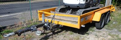 a small yellow trailer with a crane attached to it