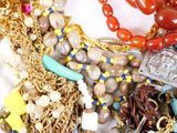a pile of assorted jewelry on a white surface