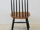 a wooden chair with black legs and a wooden seat