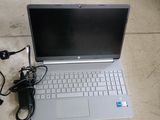 a laptop that is sitting on the ground with a charger