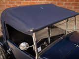 a blue car parked in front of a brick wall