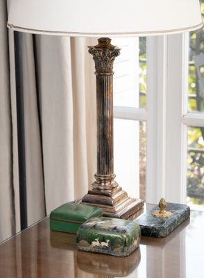 une lampe posée sur une table devant une fenêtre
