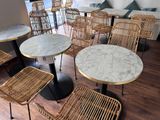 de nombreuses chaises et tables dans une pièce au sol en parquet