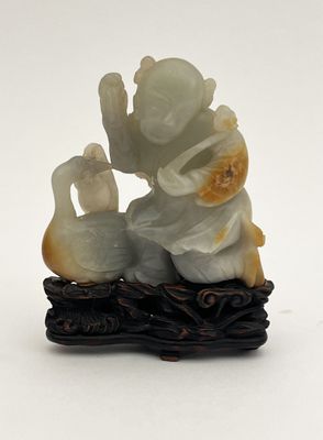une figurine représentant un homme et un canard assis sur une branche d'arbre