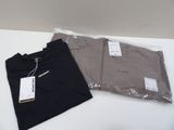 two t - shirts are sitting on a table with a price tag