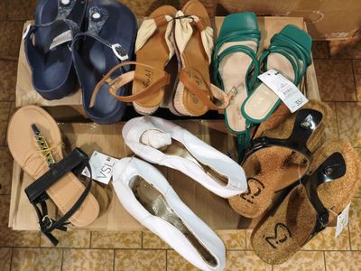 many pairs of sandals that are on the floor