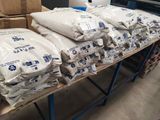 plusieurs sacs de ciment posés sur une table dans un entrepôt