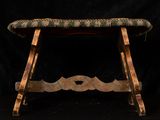 a small wooden bench with a green seat on a black background