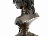 a bronze bust of a woman with curly hair on a wooden base