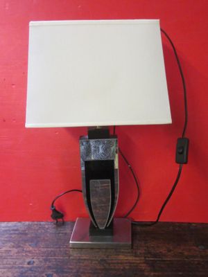 une lampe posée sur une table, avec un mur rouge en arrière-plan