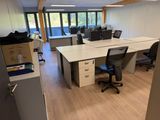 une pièce contenant deux bureaux et une chaise