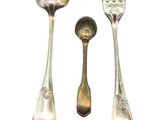 three spoons and a fork sitting next to each other