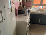 a kitchen with a refrigerator, microwave, and sink in it