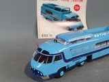 a toy bus that is sitting next to a magazine