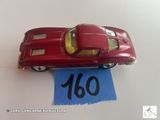 une petite voiture rouge posée sur une feuille de papier bleue