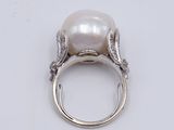 an image of a white pearl and diamond ring on a white surface