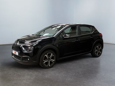 a black car is parked in a room with a white wall