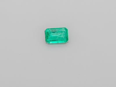 an emerald stone on a white surface