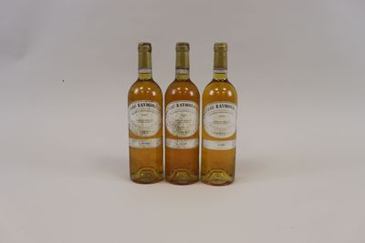 trois bouteilles de vin posées les unes à côté des autres sur une surface blanche