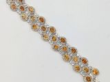 un gros plan sur un bracelet orné de pierres orange et blanches