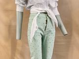 a mannequin wearing a white shirt and green pants