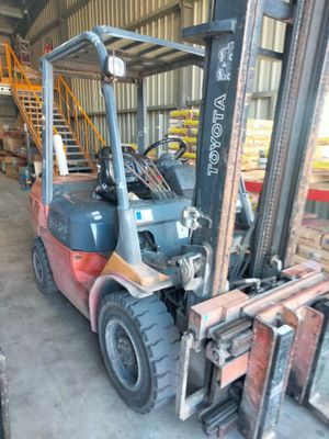 un chariot élévateur garé dans un entrepôt, avec une échelle à côté