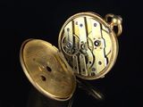 a close up of a pocket watch on a black surface