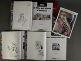 several books are sitting on a table with drawings on them