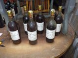 several bottles of wine are lined up on a wooden table