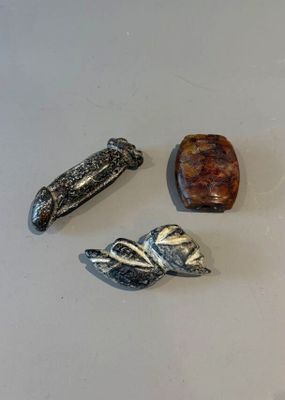 TROIS SUJETS en pierre dure figurant un phallus, un visage e…