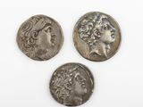 trois pièces romaines, dont l'une représente la tête d'une femme et une autre la tête d'un