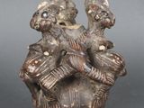 une image représentant une statue de deux personnes sur un vase